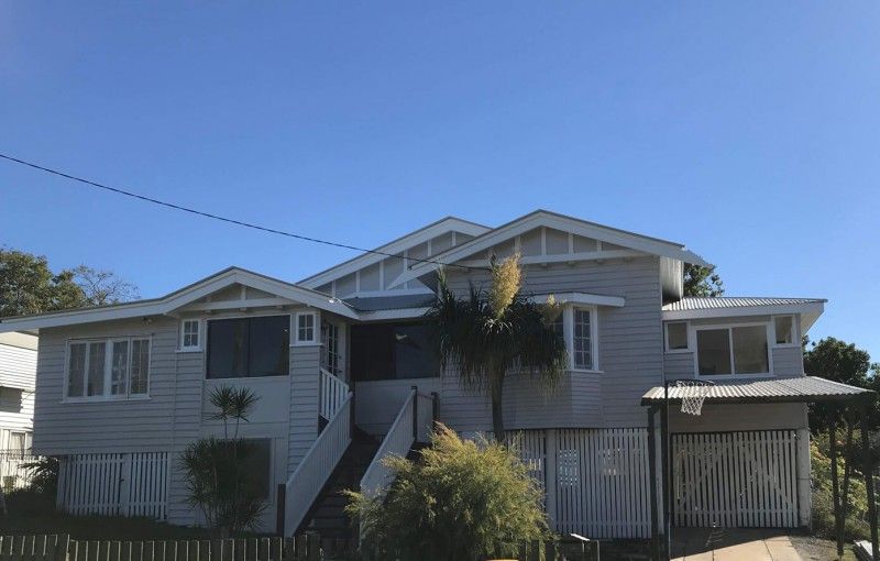 A Large White House with a Blue sky in the Background — Painting Services in Rockhampton, QLD