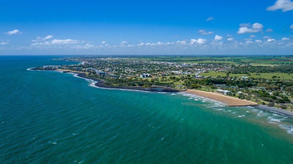 Aerial View of a Beach With a City in The Distance — Moore Park Beach Glass & Security in Bargara, QLD