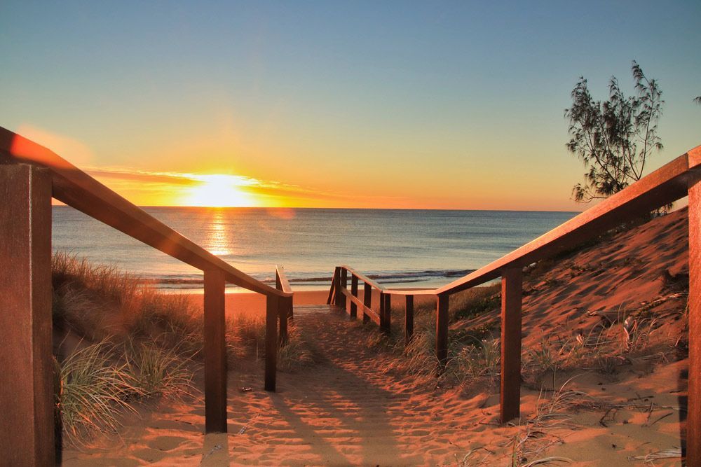 Wooden Staircase Leading to The Beach at Sunset — Moore Park Beach Glass & Security in Agnes Water, QLD