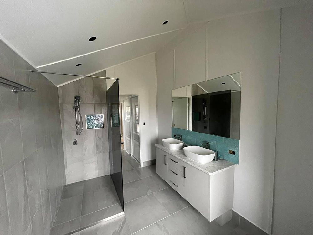 Modern Bathroom With Shower, Vanity, and Large Mirror — Moore Park Beach Glass & Security in Bundaberg, QLD