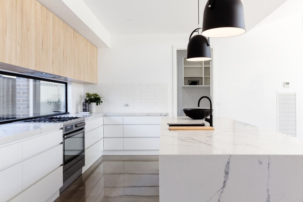 Modern Kitchen With White Countertops and Cabinets — Moore Park Beach Glass & Security in Bundaberg, QLD