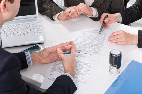 A group of business people are sitting around a table talking about business litigation.
