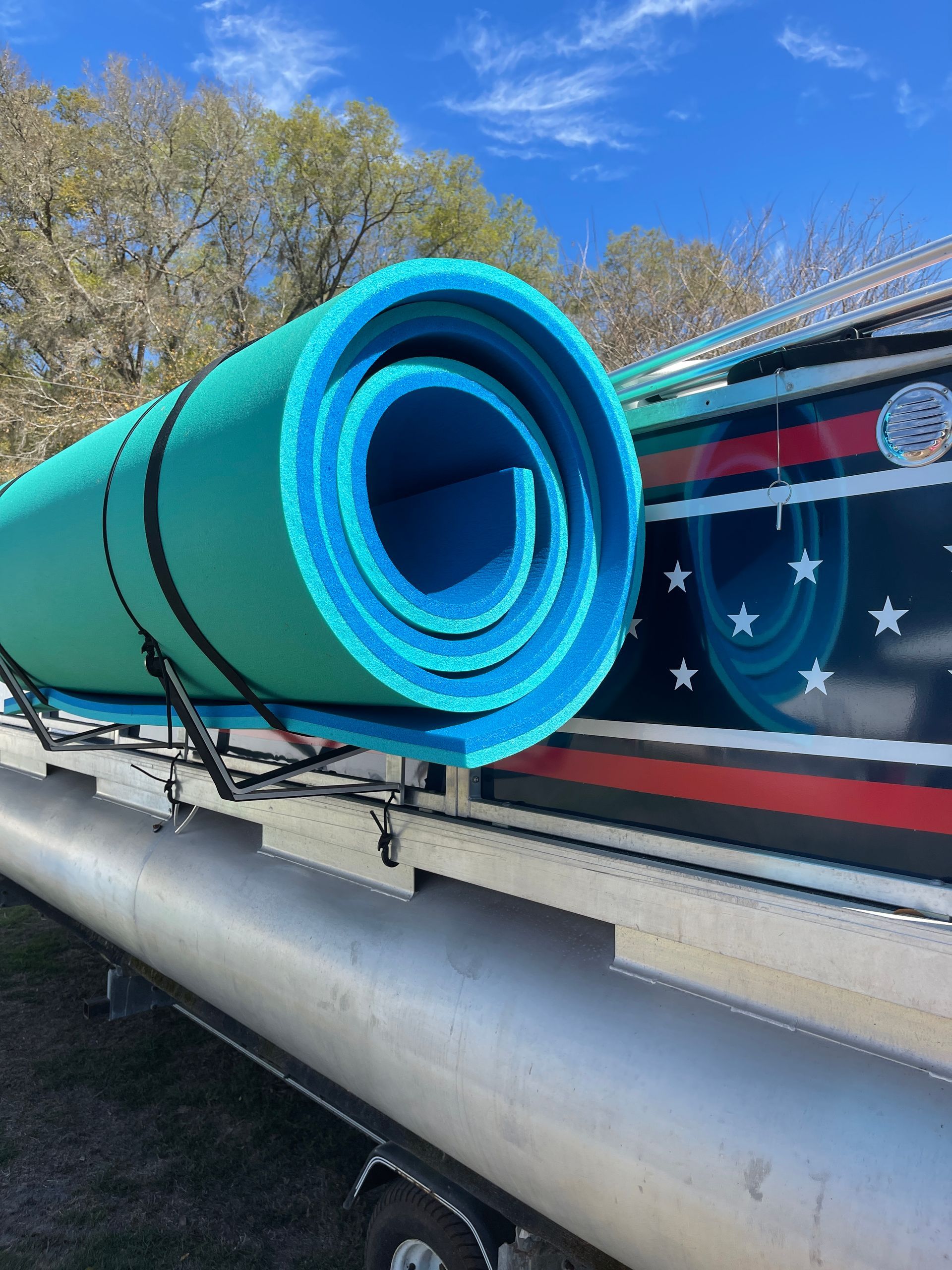 Turquoise rolled water mat on pontoon boat with text “Pontoon Boat Water Mat Solution” and “Patent Pending Design”