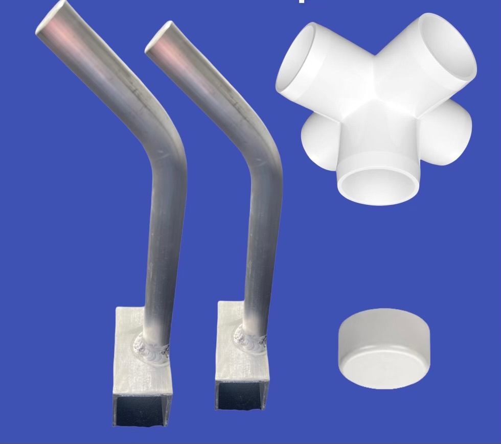 White PVC pipe fittings and two bent metal tubes on a blue background