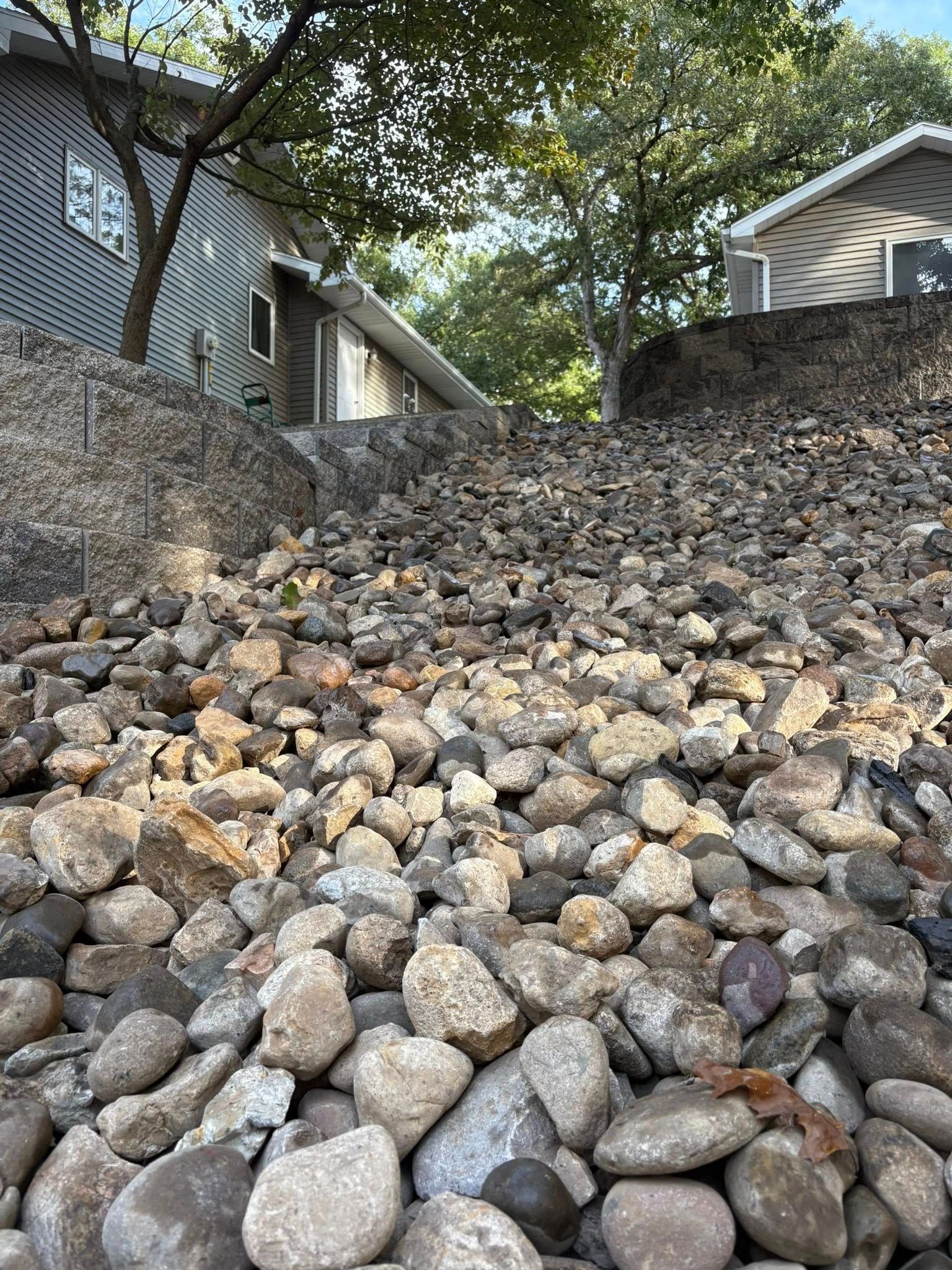 Rocky landscape sloping upward towards two houses.