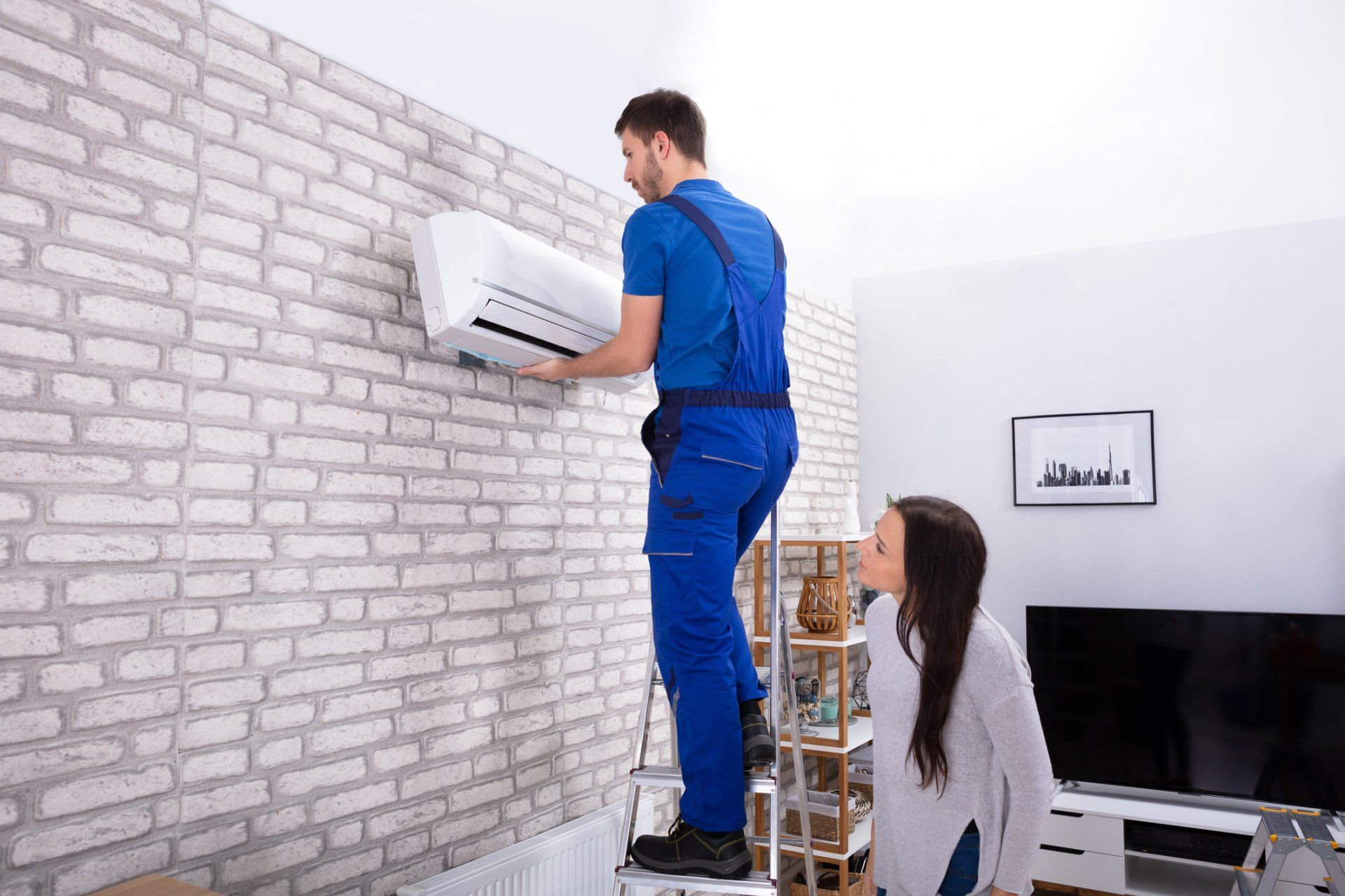 Male Technician Fixing Air Conditioner On Wall - Hendersonville, NC - Tucker Heating & Air Male Technician Fixing Air Conditioner On Wall - Hendersonville, NC - Tucker Heating & Air