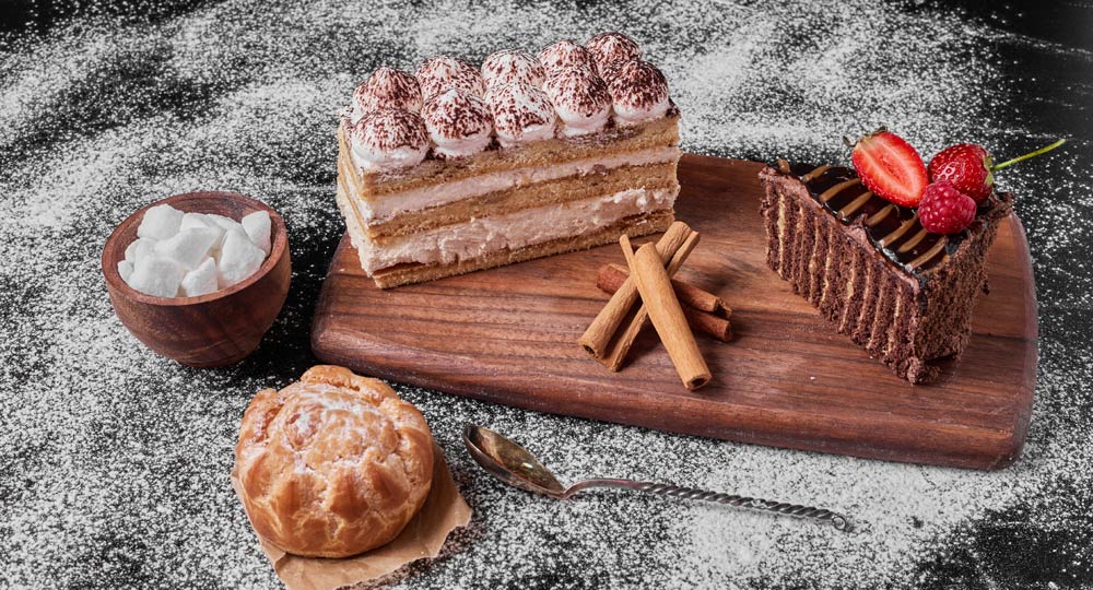 A wooden cutting board topped with a variety of desserts.
