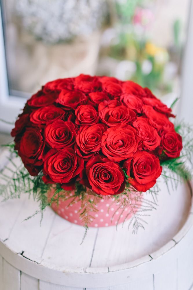 A Bunch of Red Roses in A Pink Box on A Table — Pick-A-Bunch Florists & Gifts In Sarina, QLD