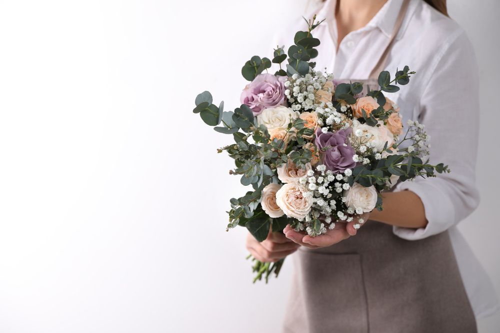 A Woman Is Holding a Bouquet of Flowers in Her Hands — Pick-A-Bunch Florists & Gifts In Alligator Creek, QLD