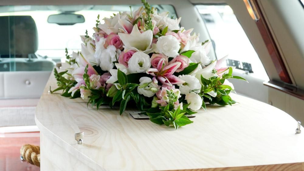 A Coffin with Flowers on Top of It Is in A Limousine — Pick-A-Bunch Florists & Gifts In Sarina, QLD