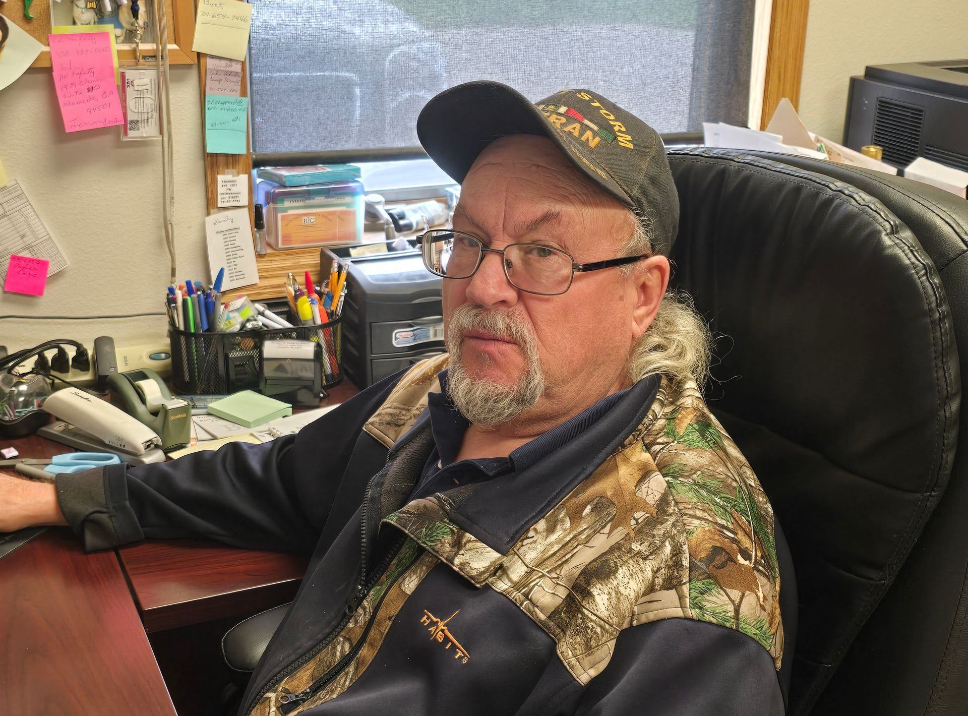 A man in a camo jacket is sitting in a chair