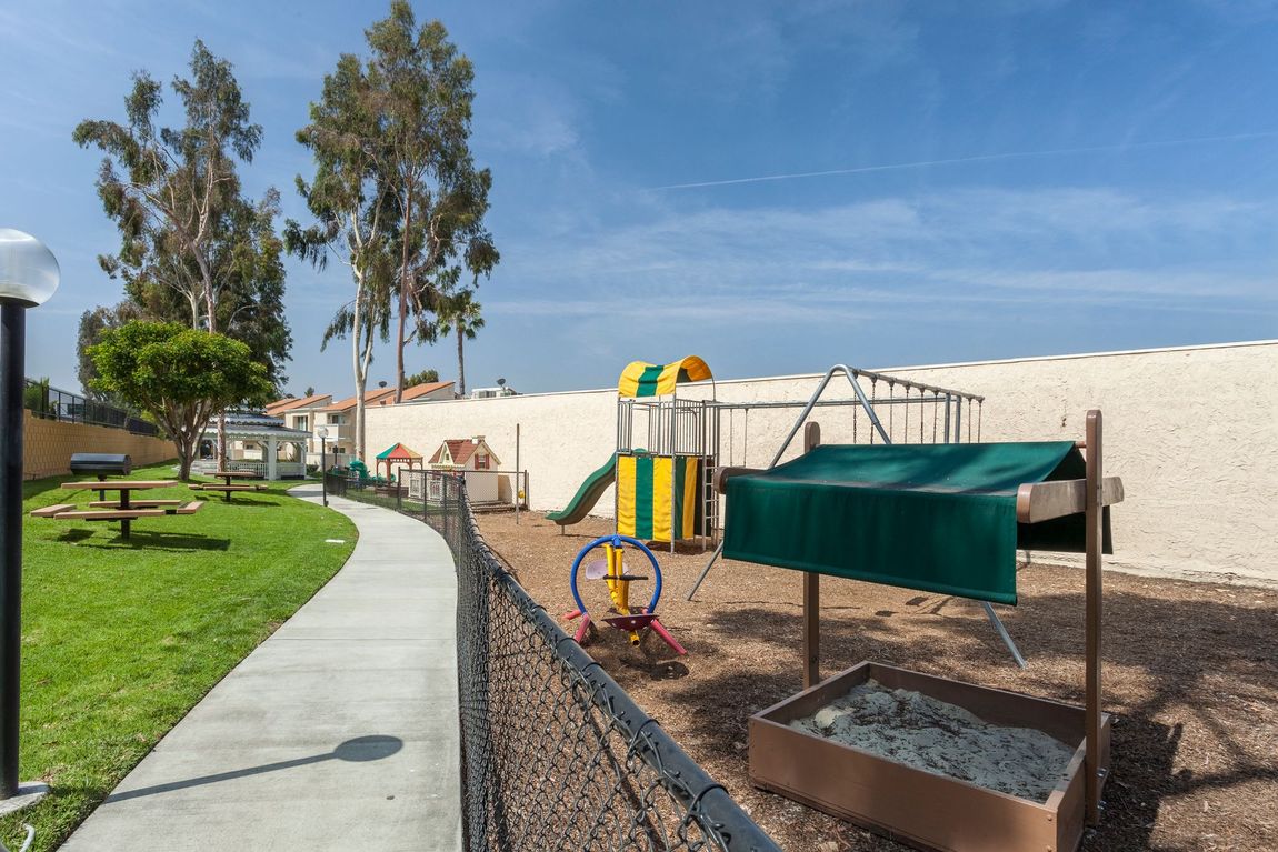 A playground with a slide and a sandbox in a park