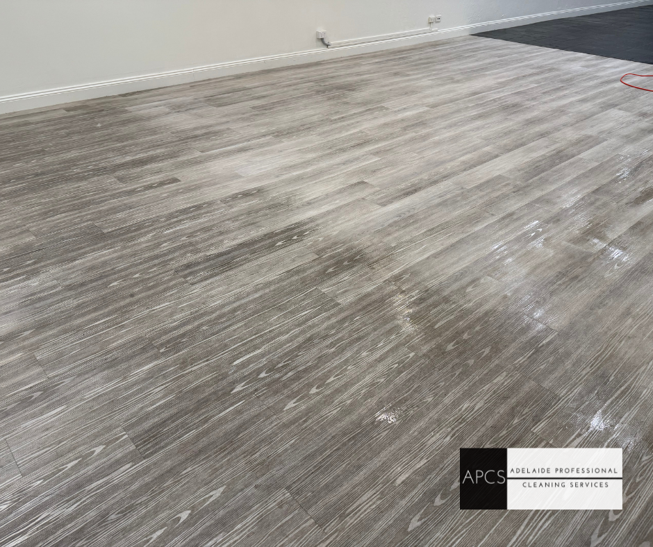 Gray wooden floor with white residue.