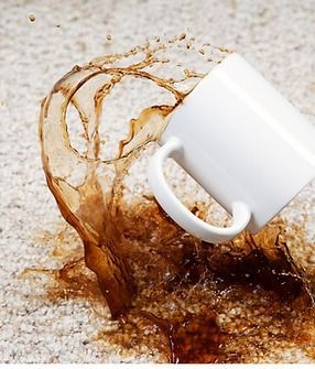 A cup of coffee has spilled on a carpet.