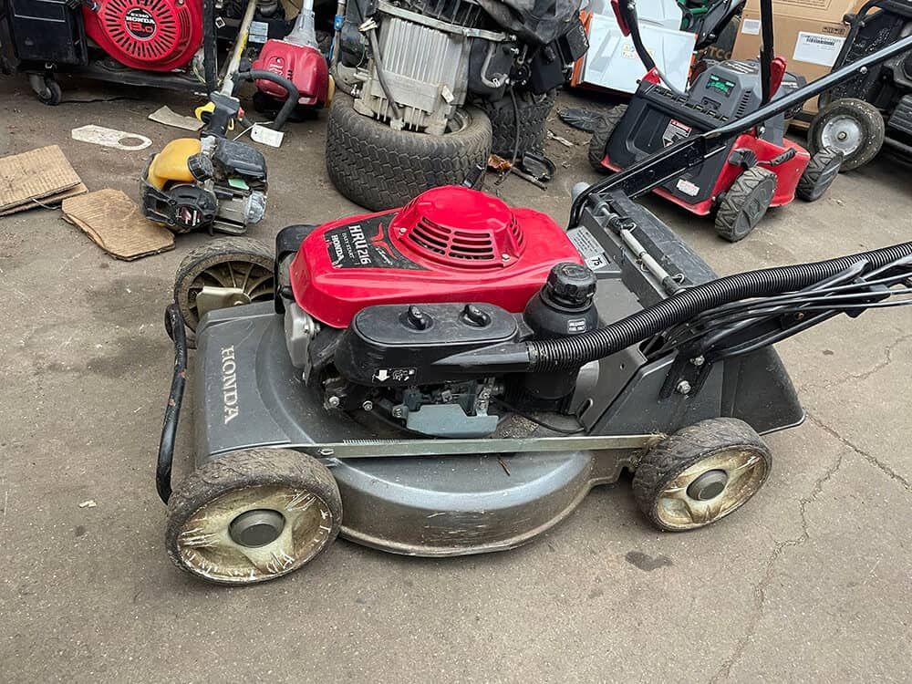 Gray Honda Lawnmower With a Red Engine in an Outdoor Setting — Cairns Small Engine Repairs in Bentley Park, QLD