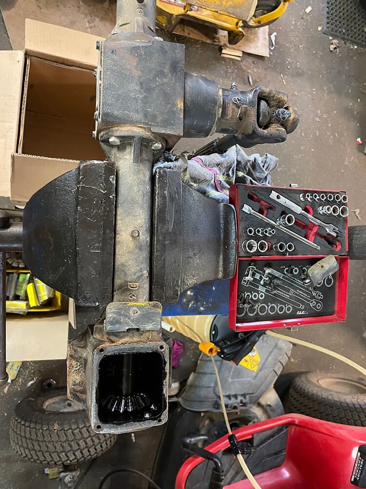 A Disassembled Black Machine Component With Exposed Gears and a Tool Set — Cairns Small Engine Repairs in Bentley Park, QLD