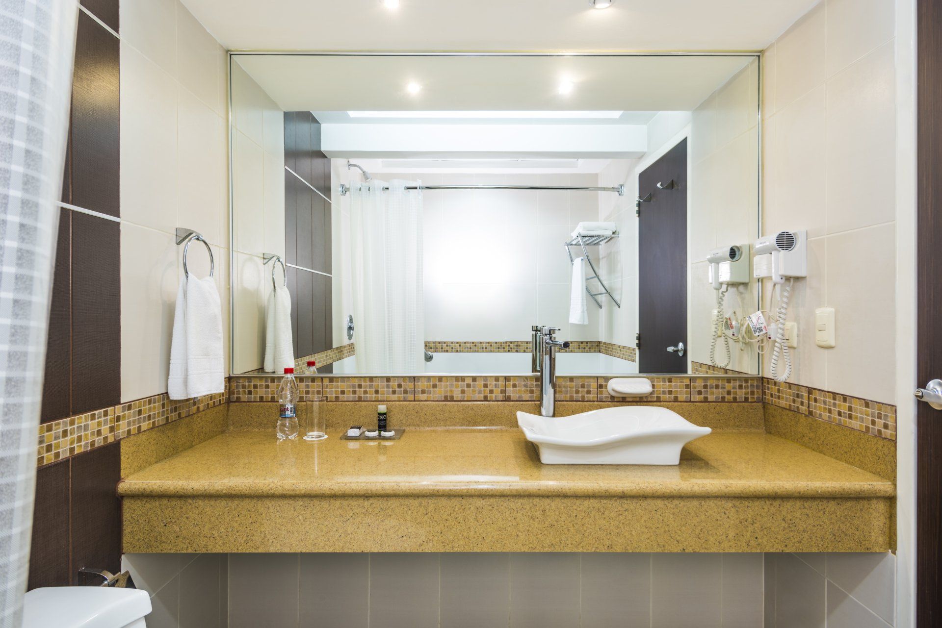 Un baño con dos lavabos y un espejo grande
