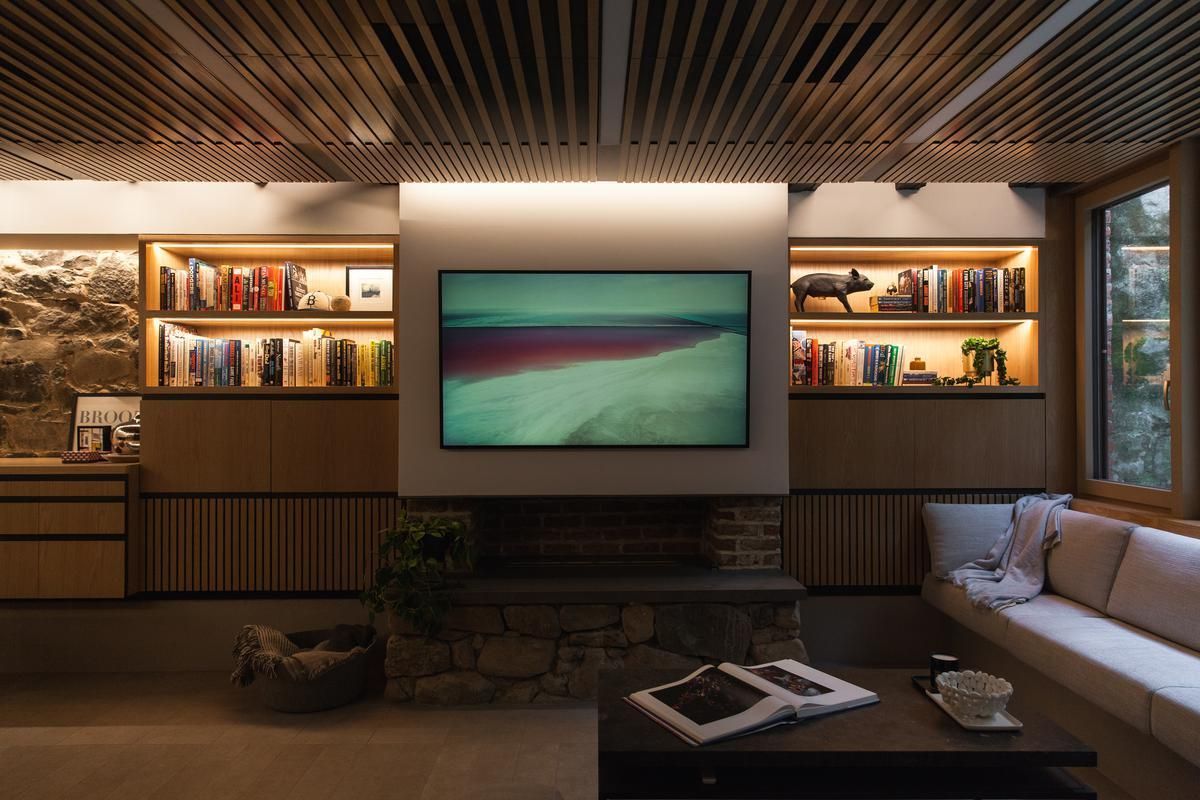 A living room with a couch and a television on the wall.