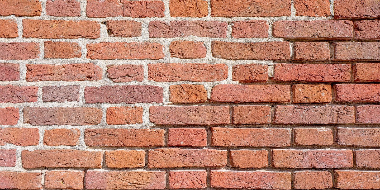 A close up of a brick wall with a few bricks missing.