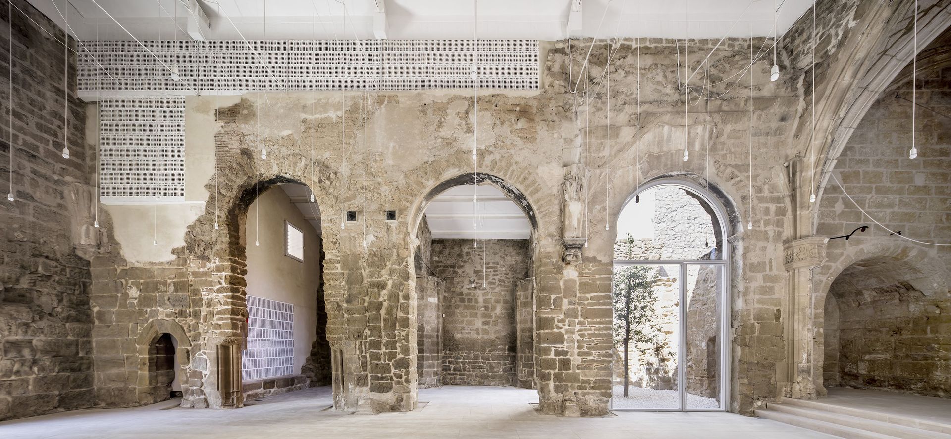 A large empty room with brick walls and arches.