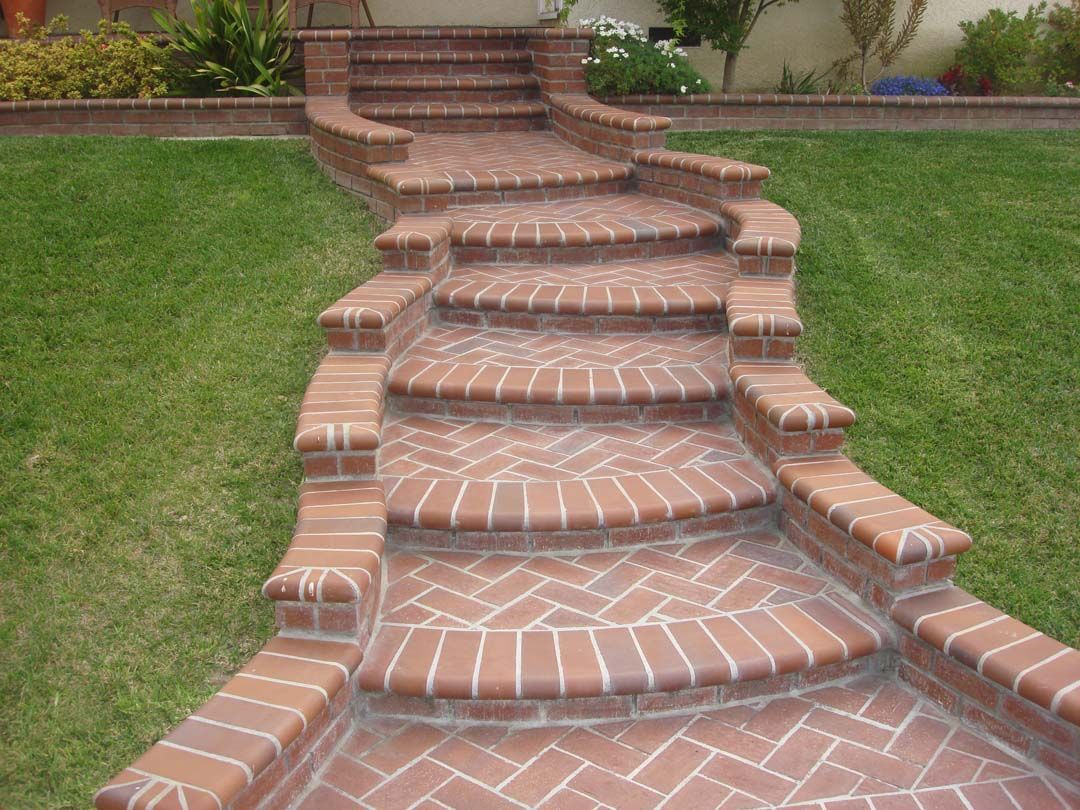 A brick walkway with stairs leading up to a house