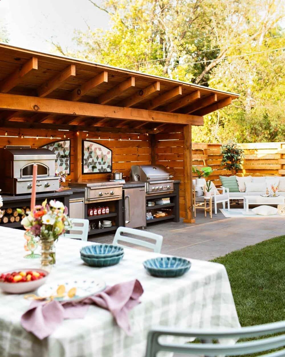 A patio with a table and chairs under a wooden roof