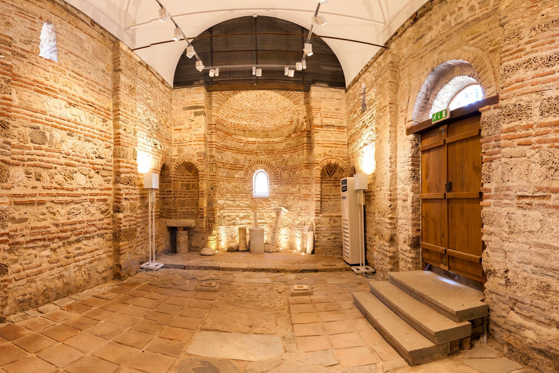 An empty room with brick walls and wooden doors
