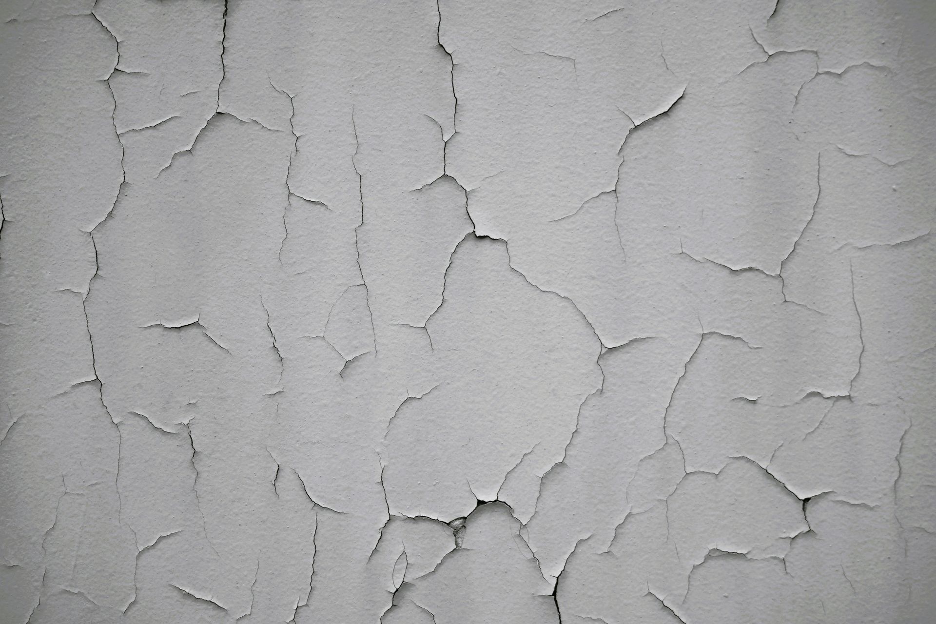 A close up of a cracked white wall