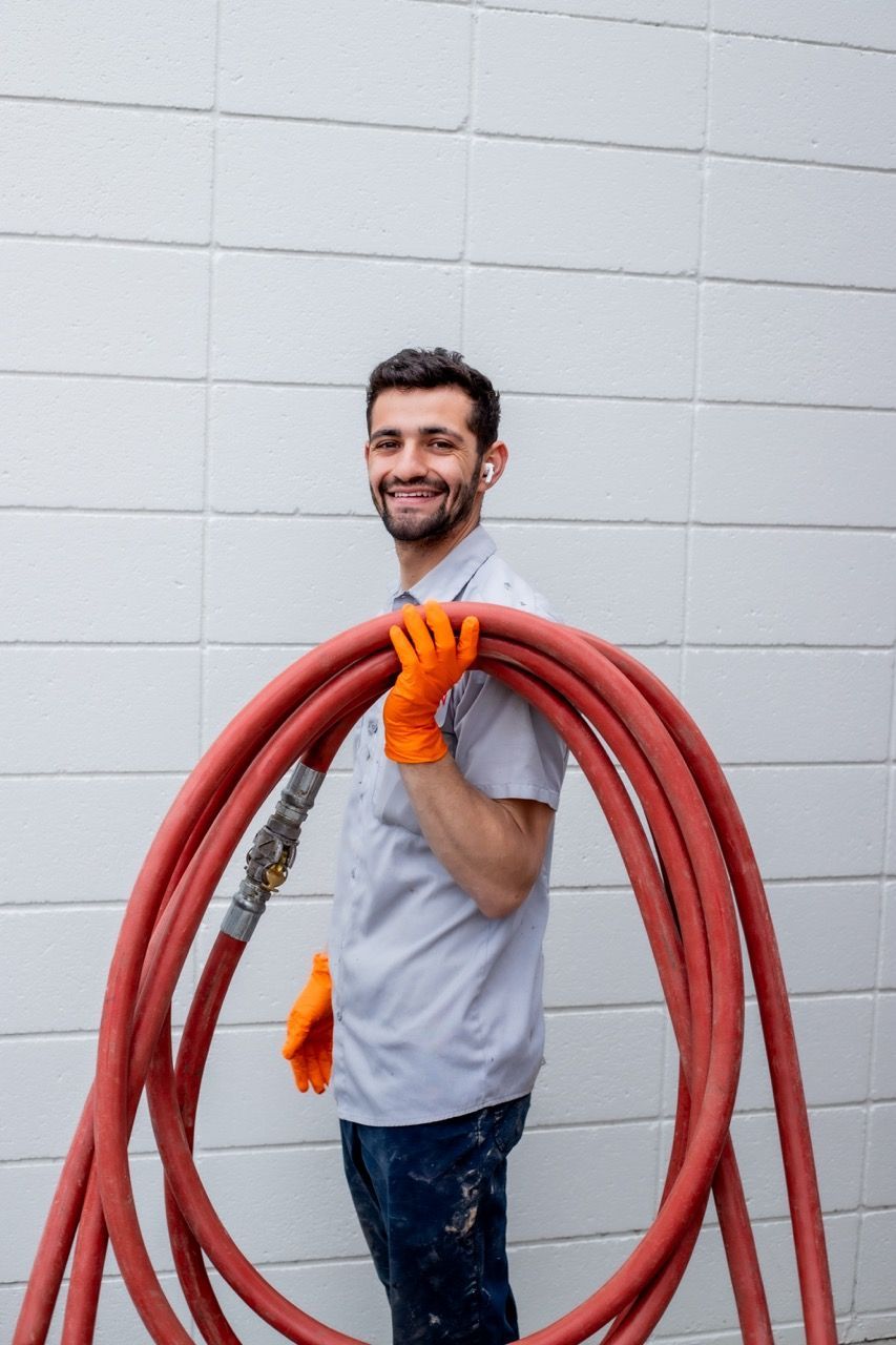 Supervisor transporting a hose for plumbing project