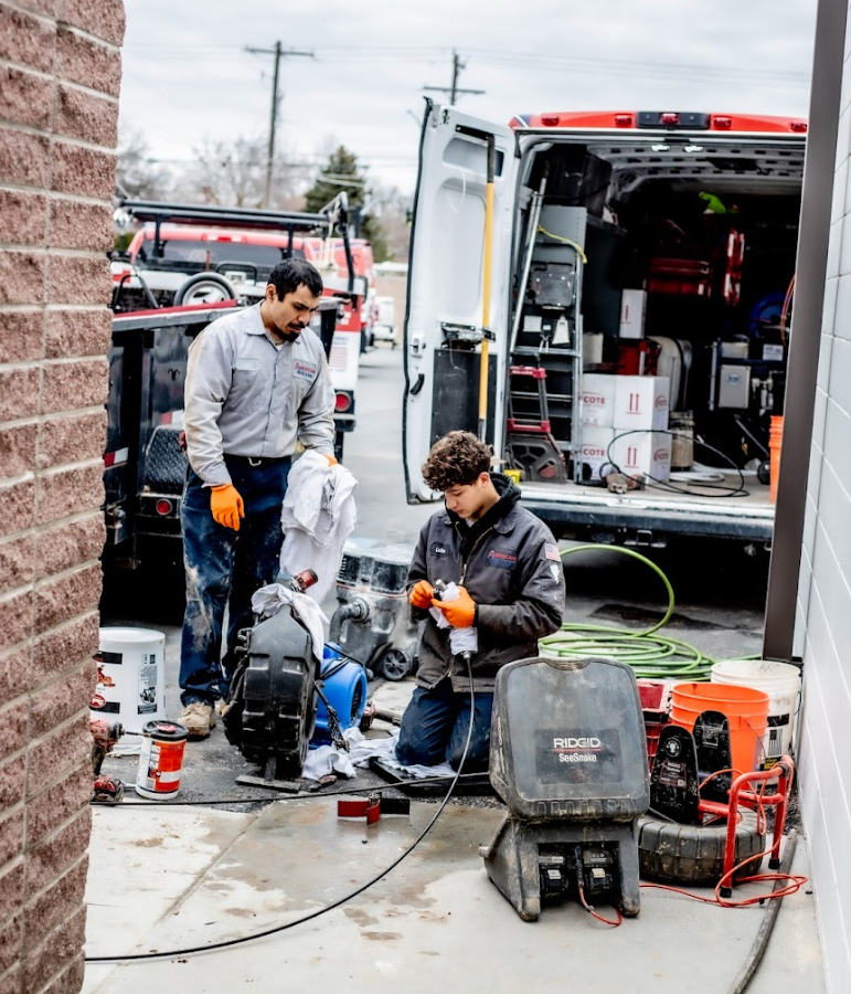 Drain technicians and underground plumbing crew working an elementary school to replace busted pipes