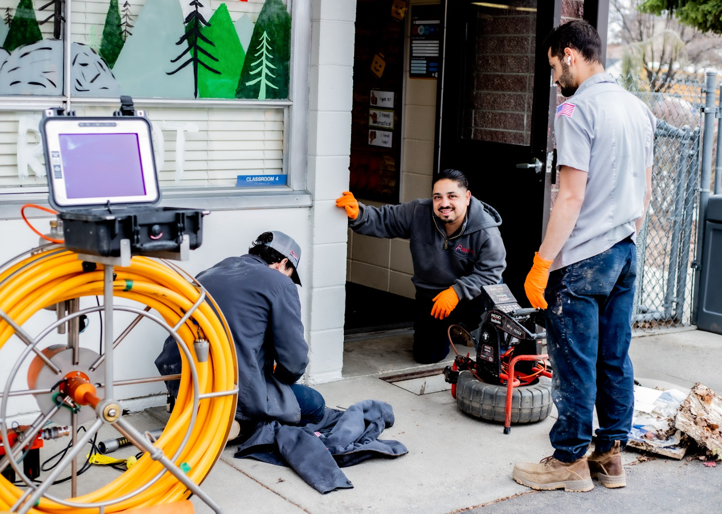 Drain technicians and underground plumbing crew working an elementary school to replace busted pipes