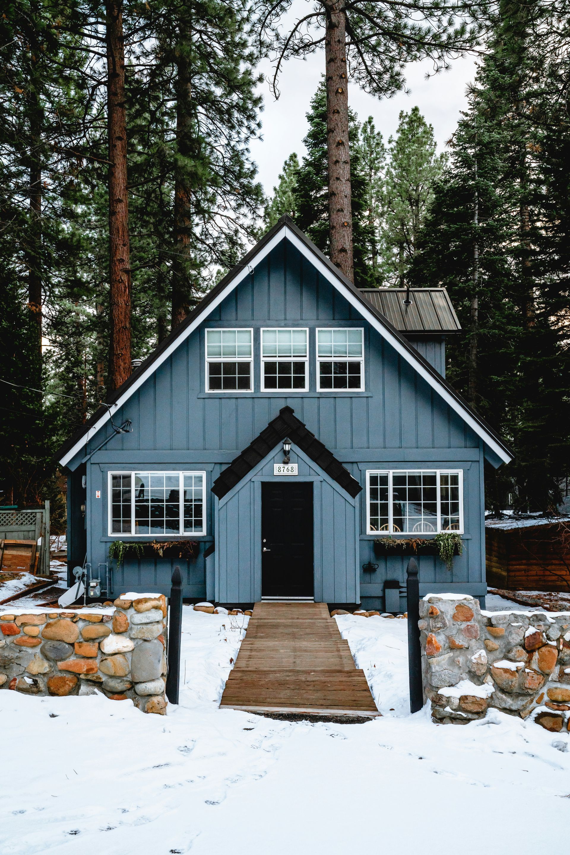 Exterior of a blue home in the snow.