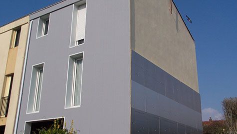 Un bâtiment avec beaucoup de fenêtres et un ciel bleu en arrière-plan