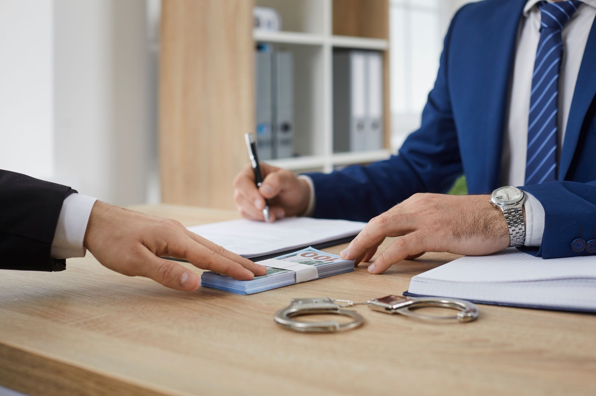 Male businessman gives money bundle to man who signs document agreement. Male businessman gives money bundle to man who signs document agreement.