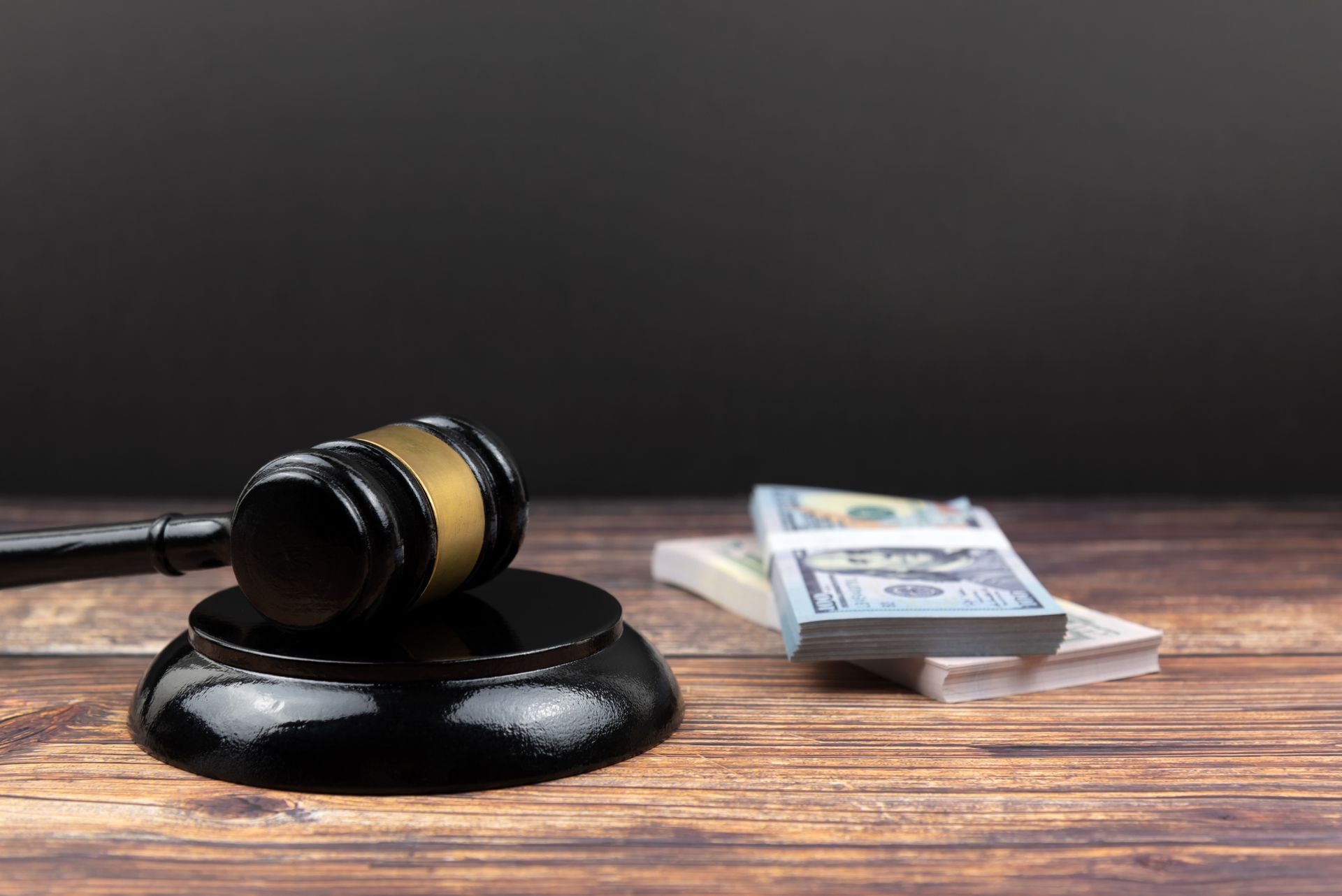 A judge’s gavel rests on a table with money, representing 24/7 bail bond services.