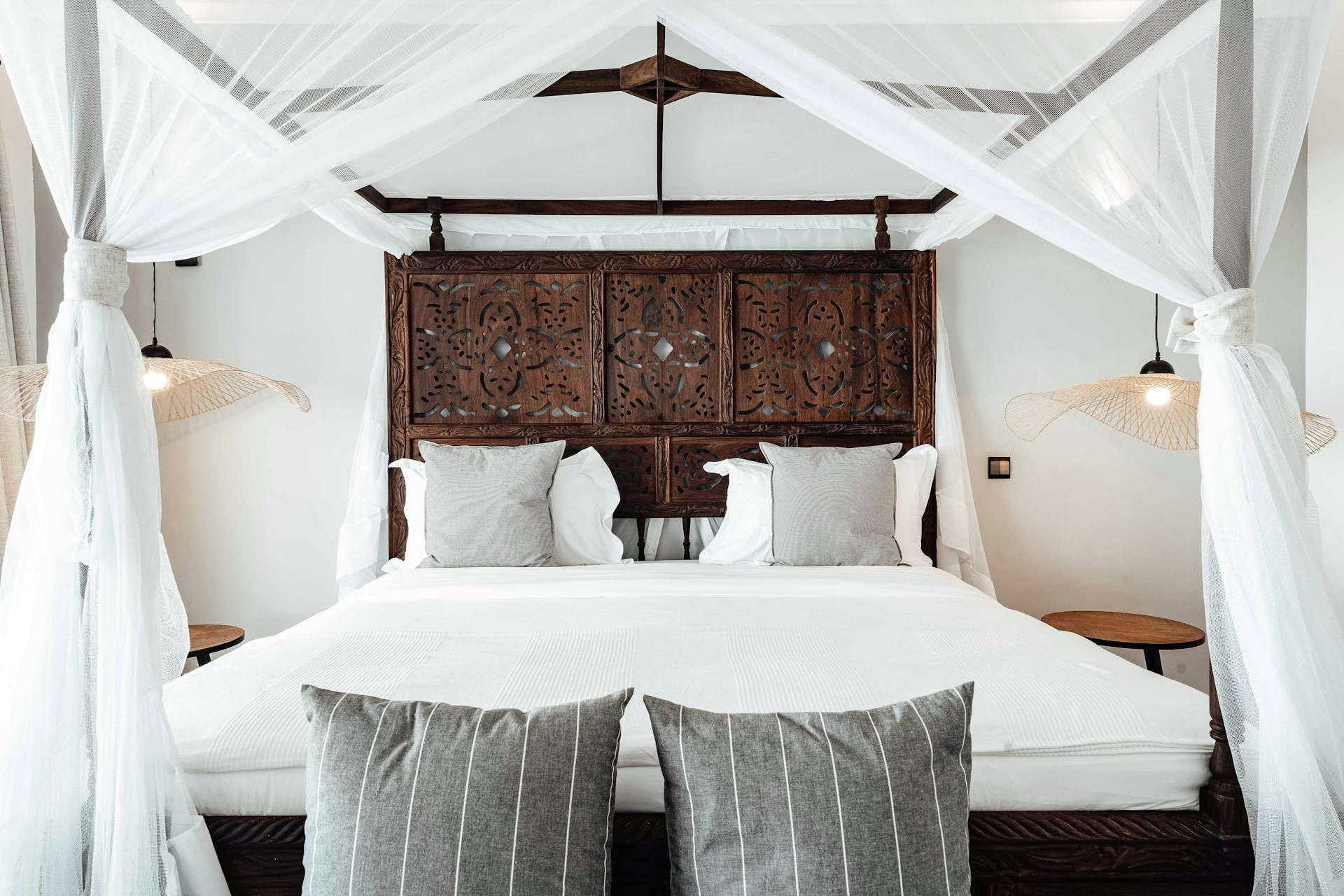 A bed with a canopy and pillows in a bedroom.