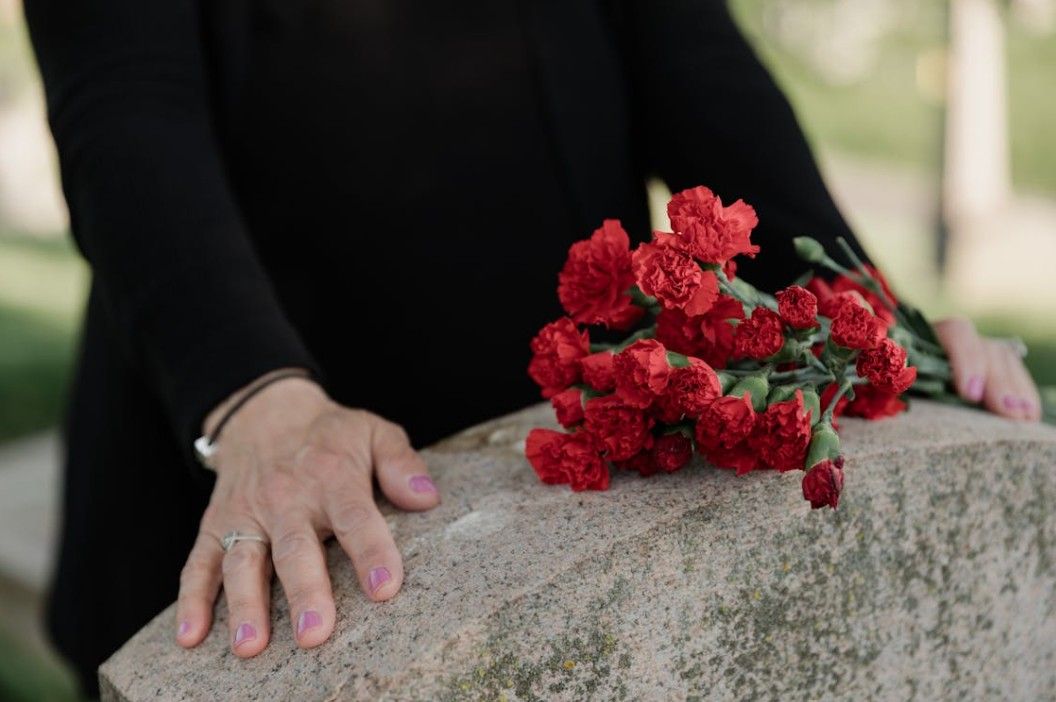 Red carnations placed on a memorial stone, symbolizing compassionate funeral and cremation support for Poulsbo, WA families