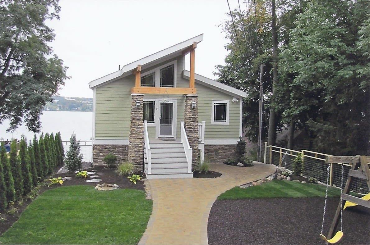 A small house with a swing set in front of it