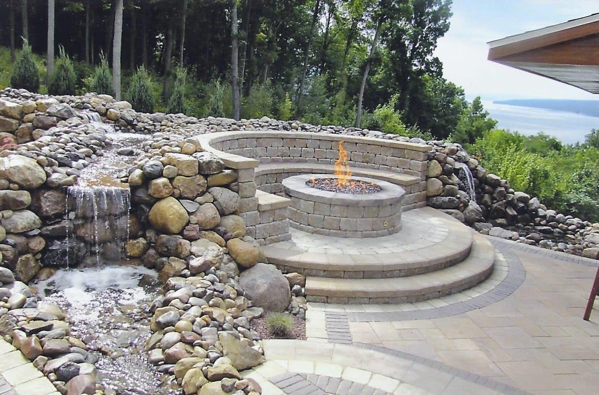 A fire pit with a waterfall in the background