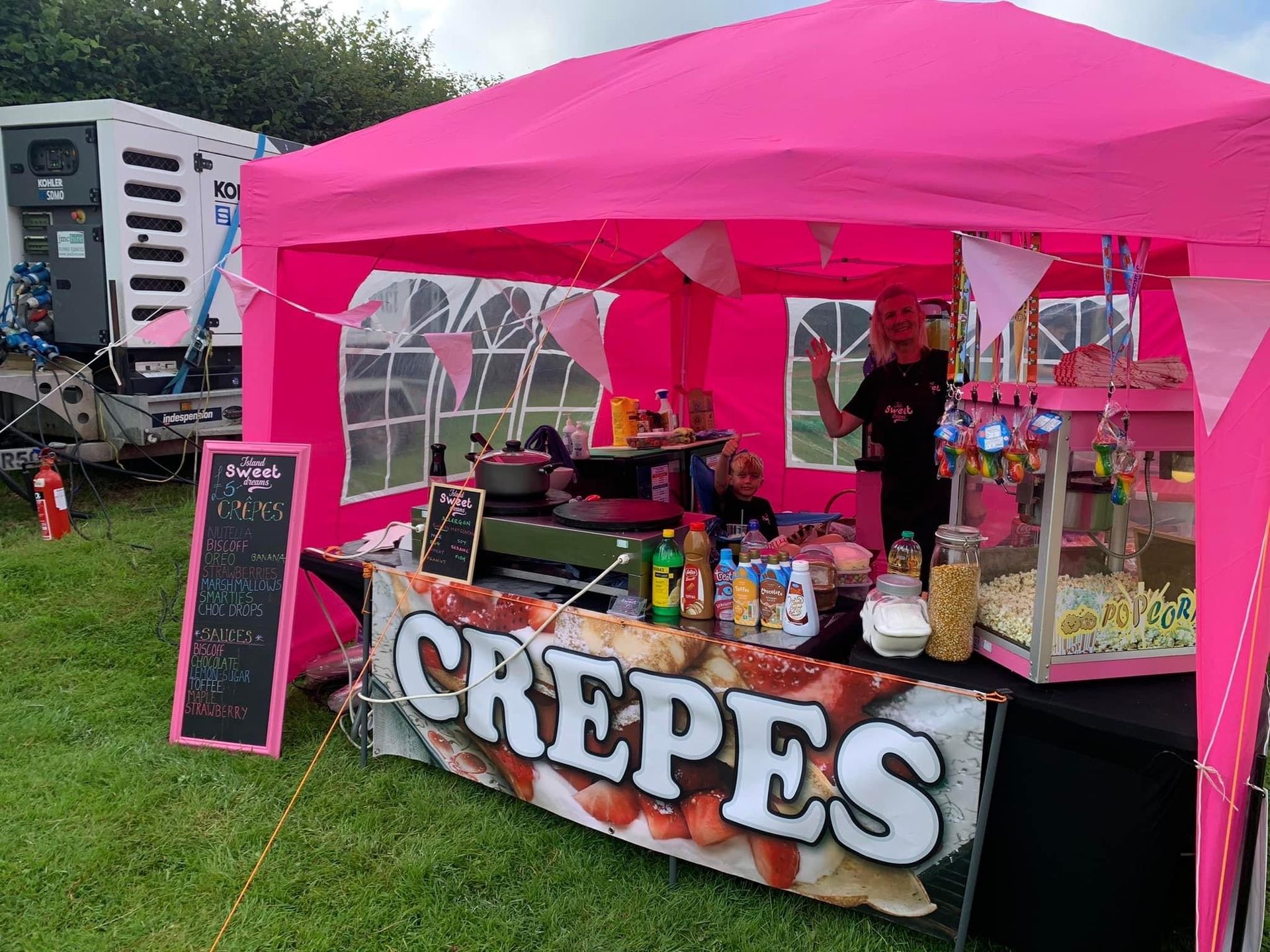 Pink crepe stand with a person inside; serving crepes.