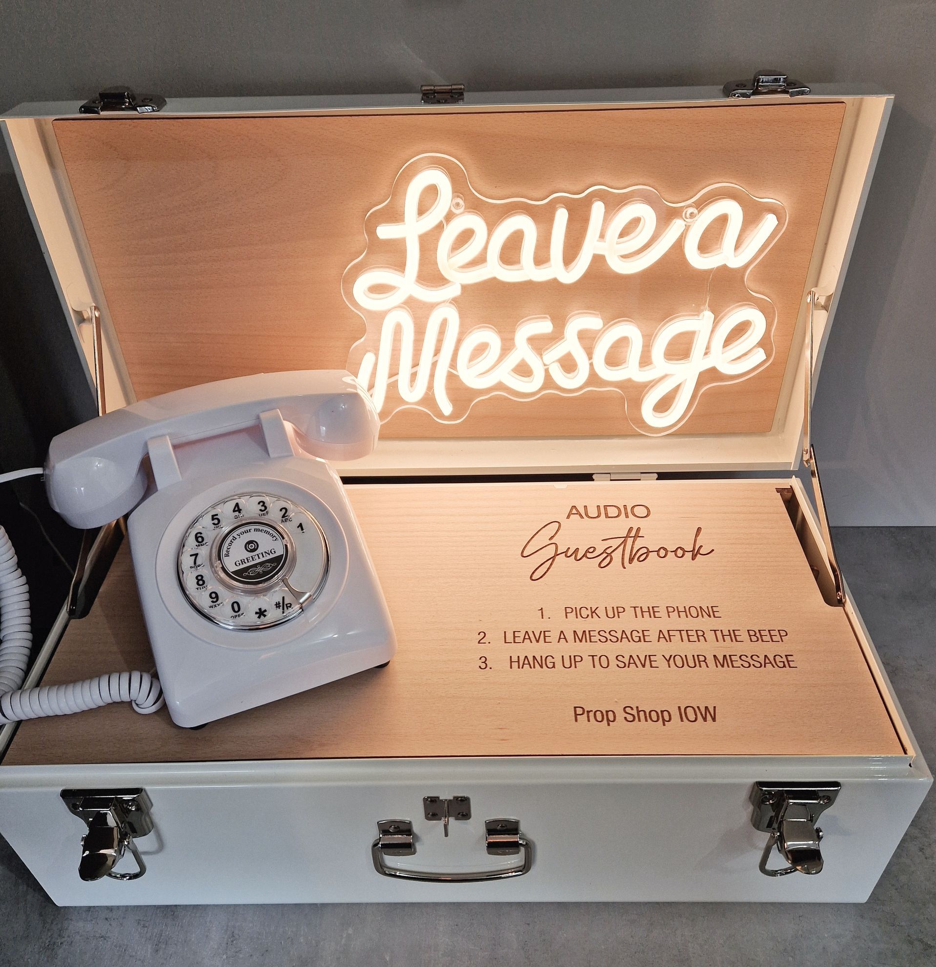 White suitcase with rotary phone and neon