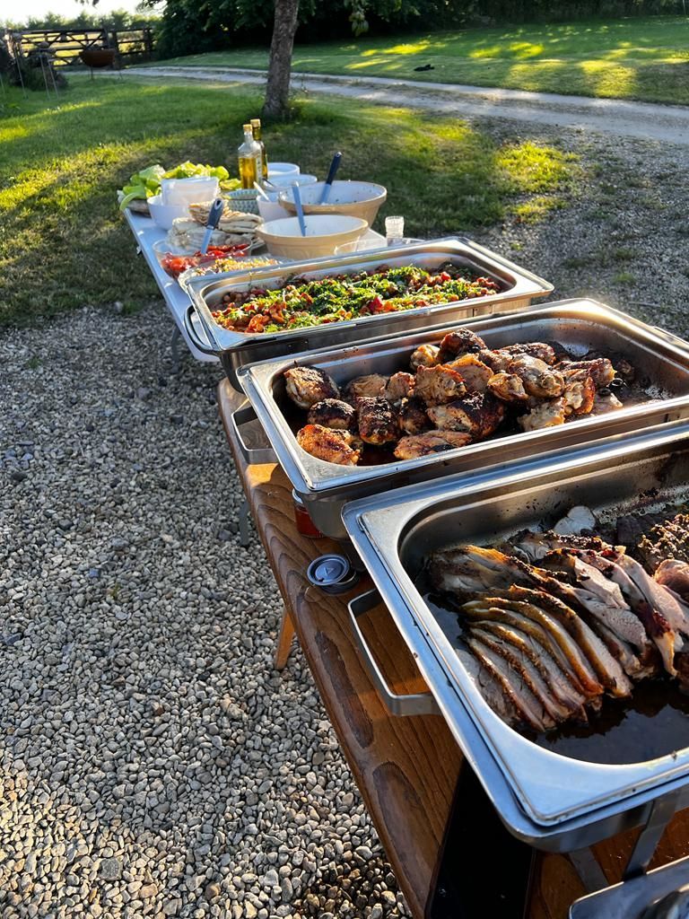Outdoor buffet table with various dishes: salads, meats, and vegetables.
