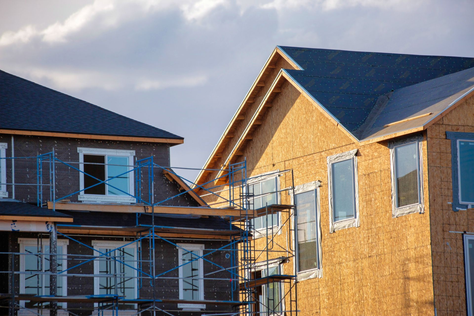 A row of houses under construction with scaffolding around them