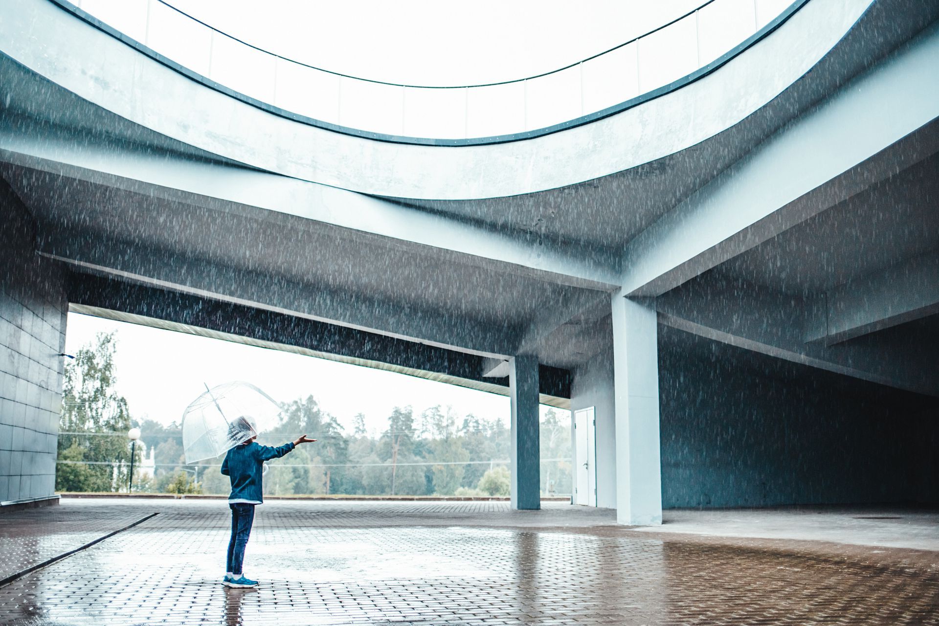 A person is standing in the rain in a building.
