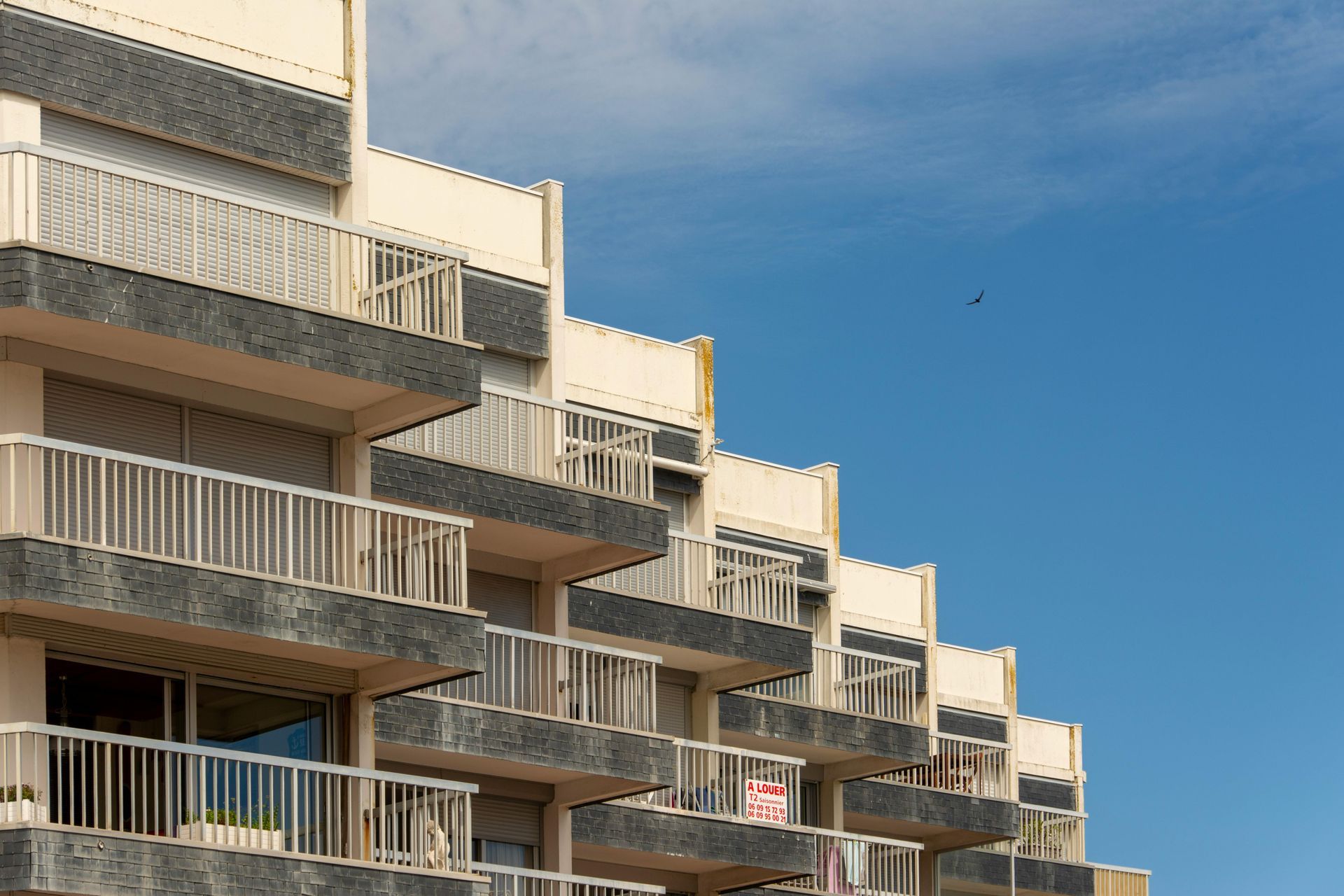 A building with a lot of balconies and a blue sky in the background.