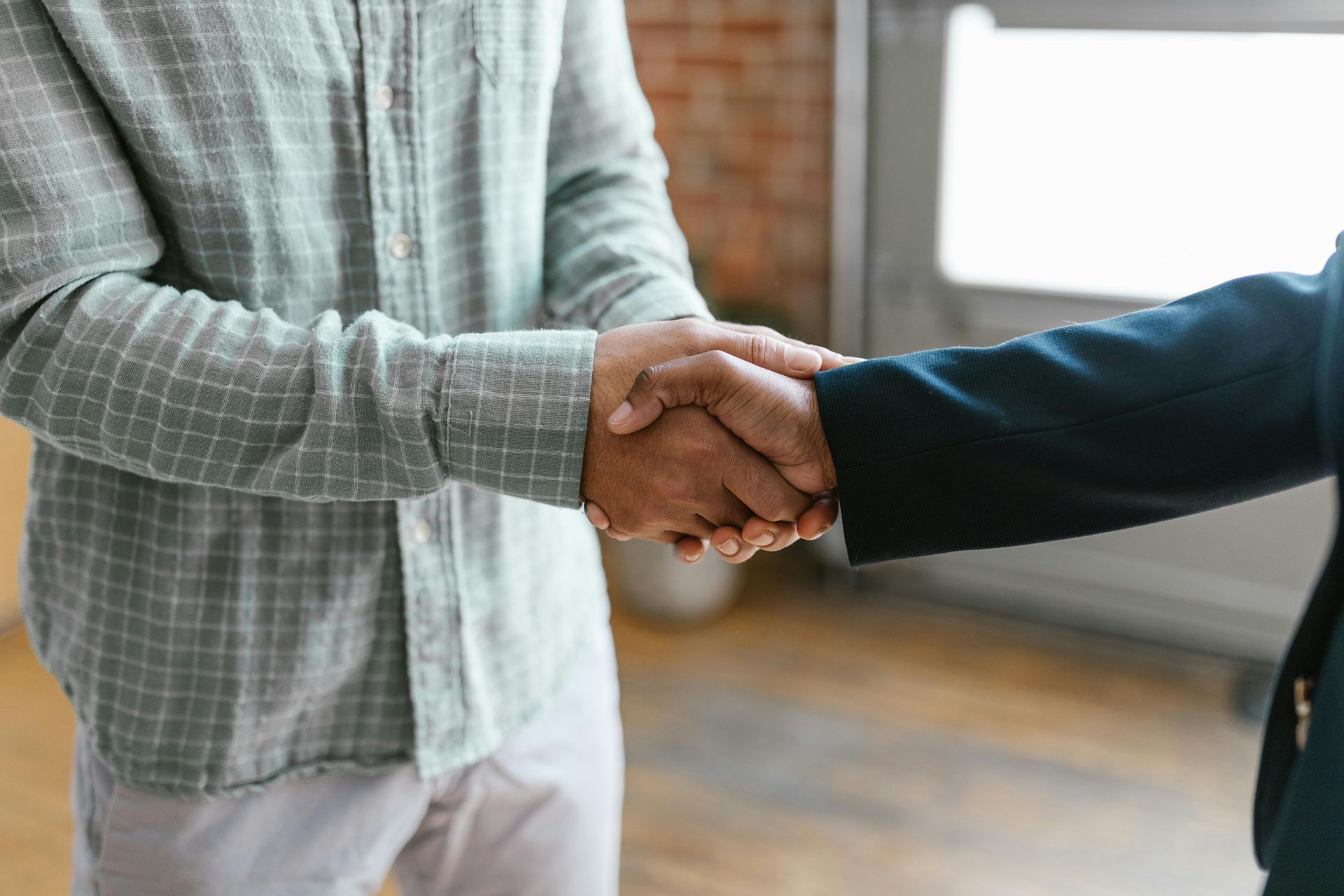 Two men are shaking hands in a room.
