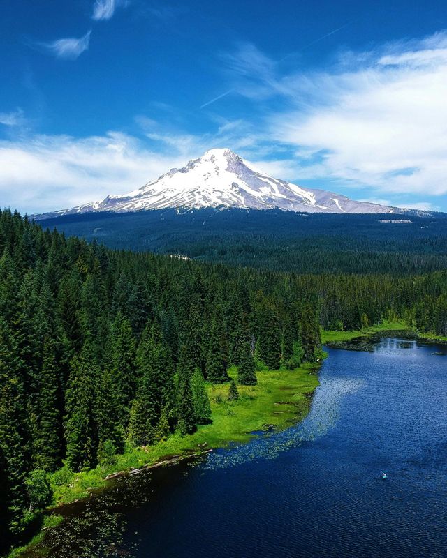 A lake surrounded by trees with a mountain in the background