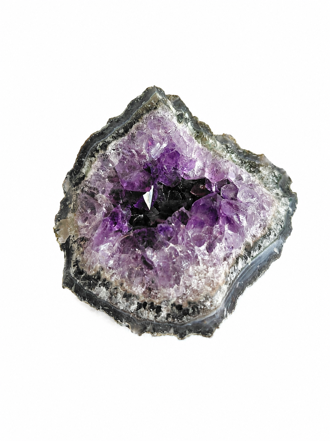 Paarse amethistkristalgeode met een sprankelend hol midden op een witte achtergrond