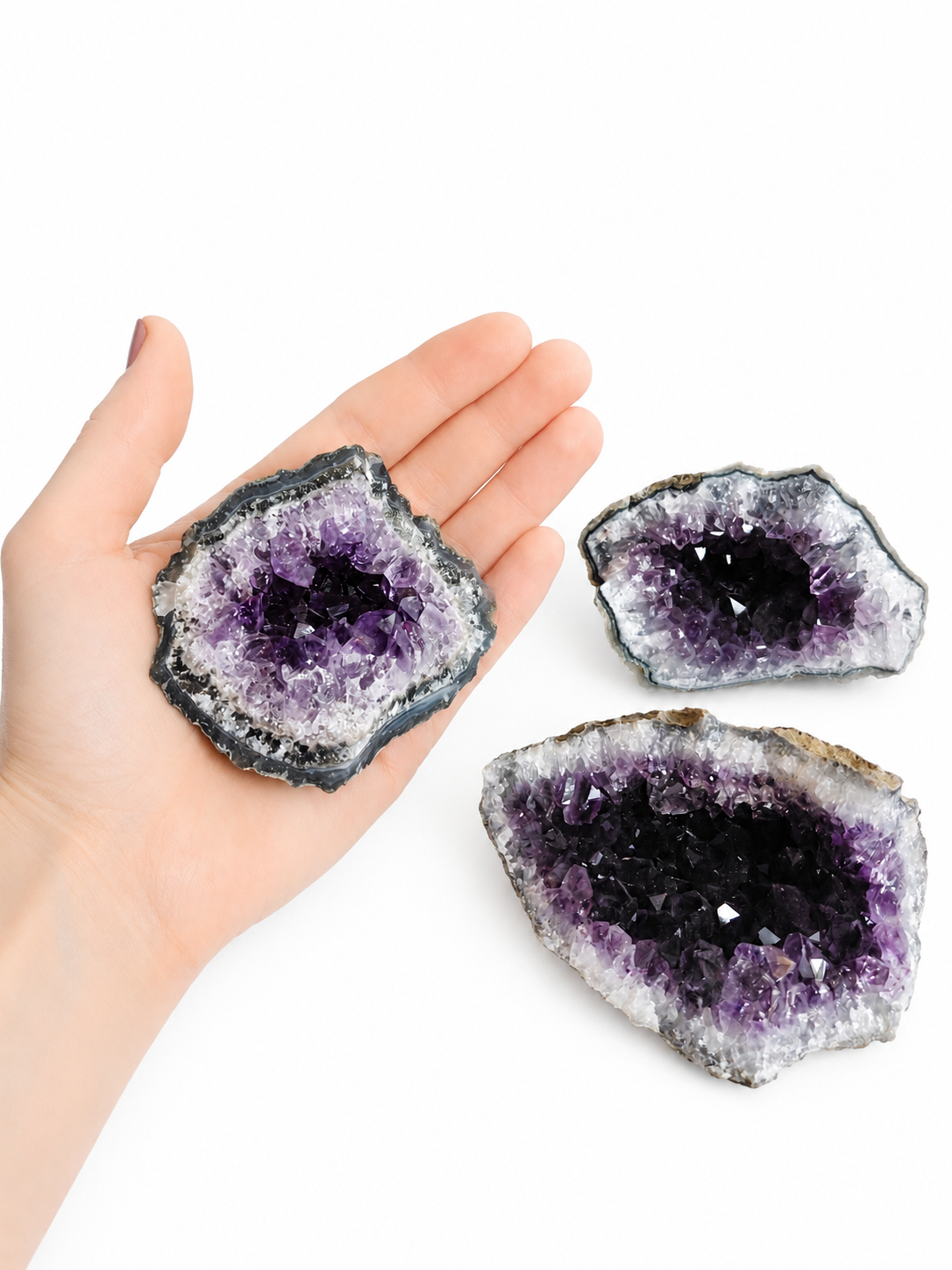 Paarse amethistkristalgeode met een sprankelend hol midden op een witte achtergrond