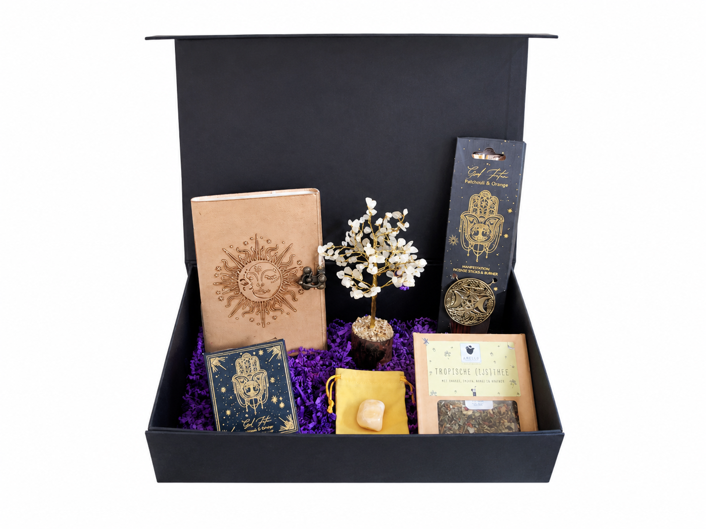 Zwarte geschenkdoos met diverse goudkleurige verpakkingen, kaarten en bloemen op een paarse achtergrond.